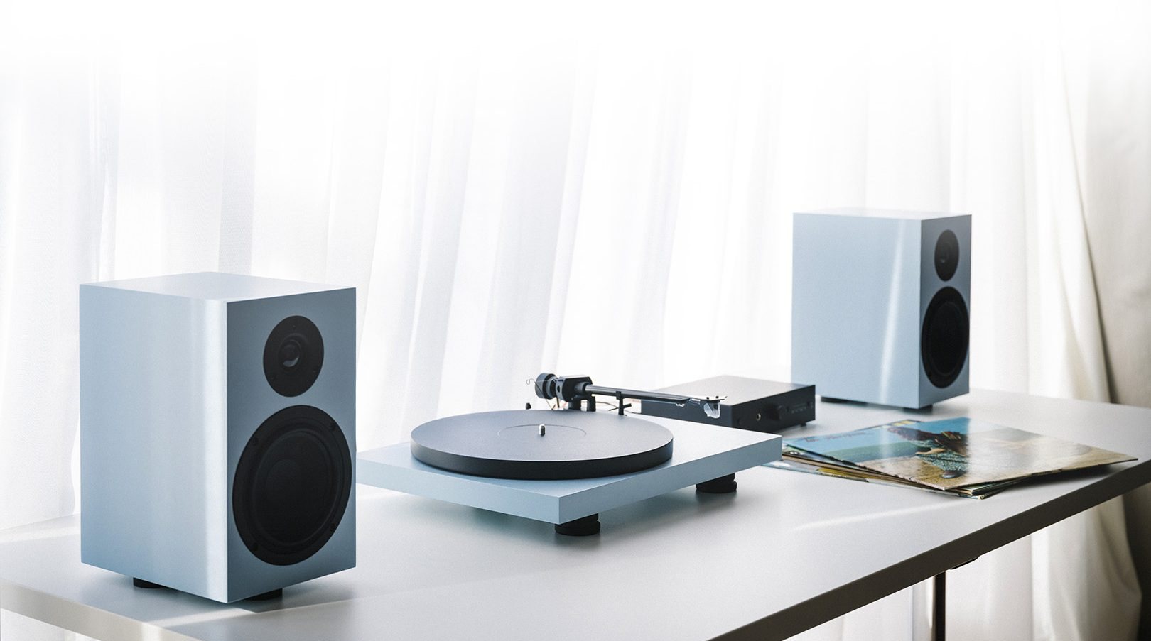 Pro-Ject Plattenspieler mit Lautsprechern auf einem hellen Tisch